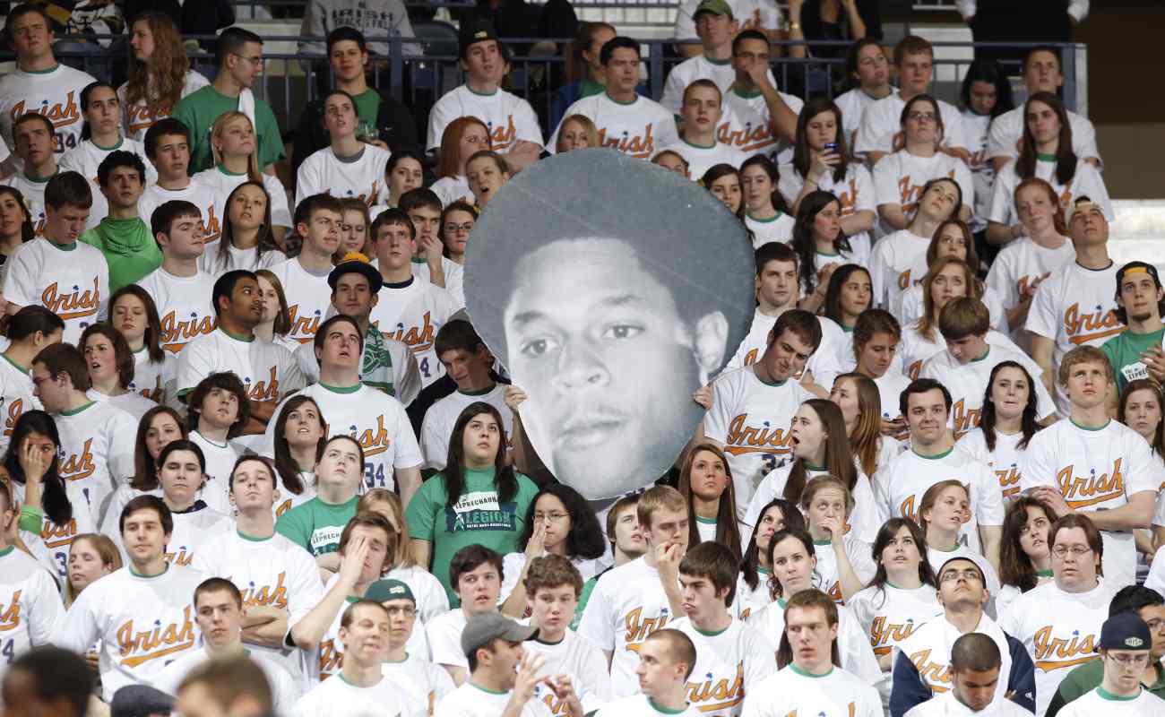  Notre Dame Fighting Irish fans hold up a cutout of former Irish great Austin Carr during basketball game