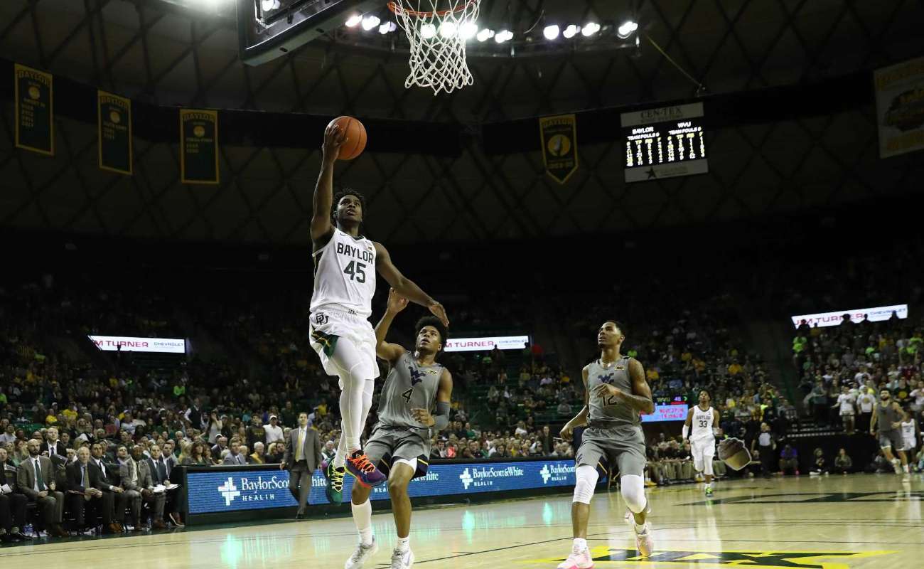 Davion Mitchell of Baylor Bears takes a shot against Miles McBride of West Virginia Mountaineers