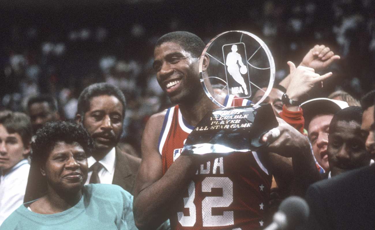 Earvin Magic Johnson #32 of West NBA All-Stars holds up the Most Valuable Player trophy 1990