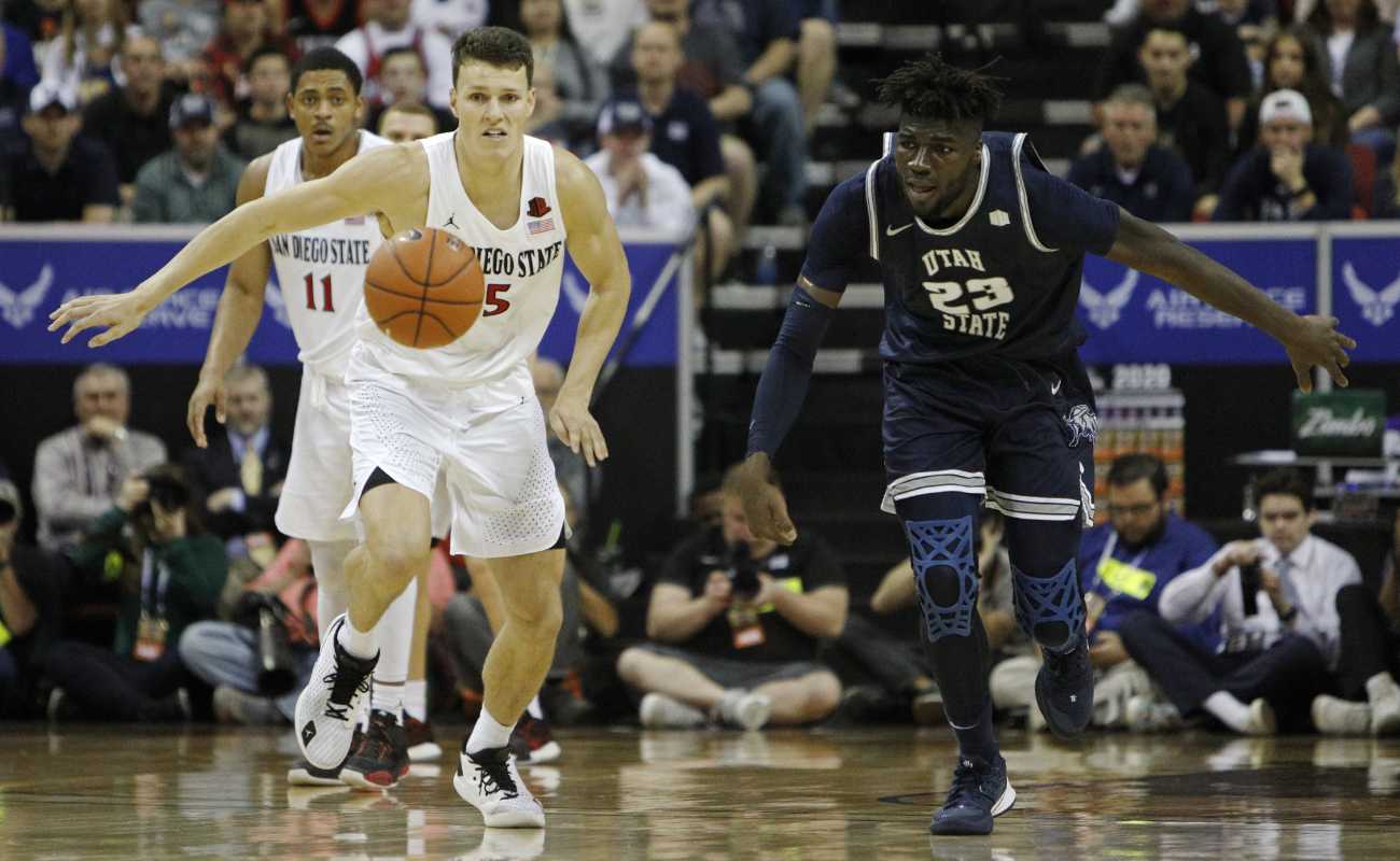 Yanni Wetzell of San Diego State Aztecs and Neemias Queta of Utah State Aggies go for the loose ball during the championship game 