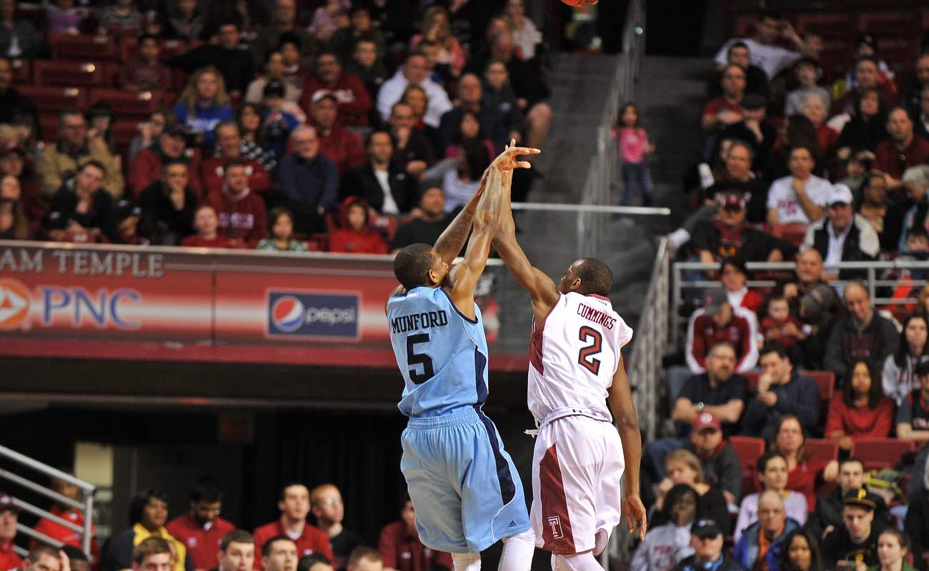 Temple University contests a jumper by URI during basketball game