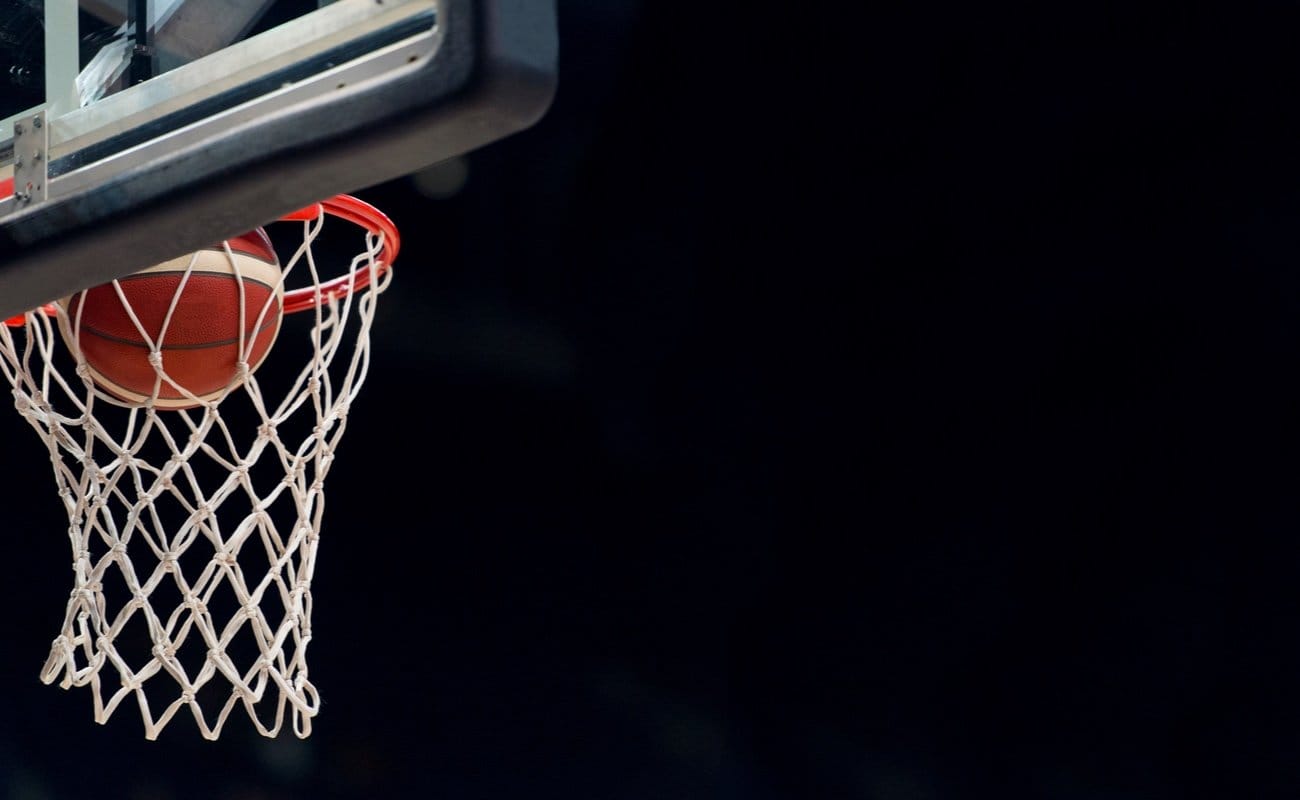 basketball in hoop against black background