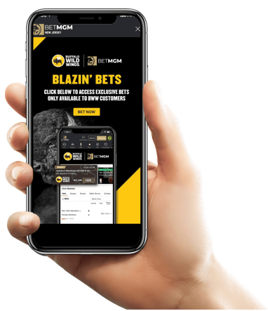 A right hand holding a smartphone with the Buffalo Wild Wings x BetMGM offer on the screen