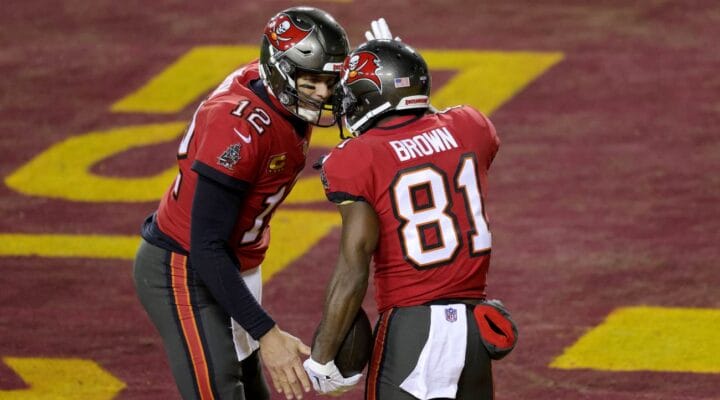 Quarterback Tom Brady #12 and wide receiver Antonio Brown #81 of the Tampa Bay Buccaneers celebrate after connecting for a first half touchdown pass against the Washington Football Team in the NFC Wild Card playoff game at FedExField on January 09, 2021 in Landover, Maryland. (Photo by Rob Carr/Getty Images)