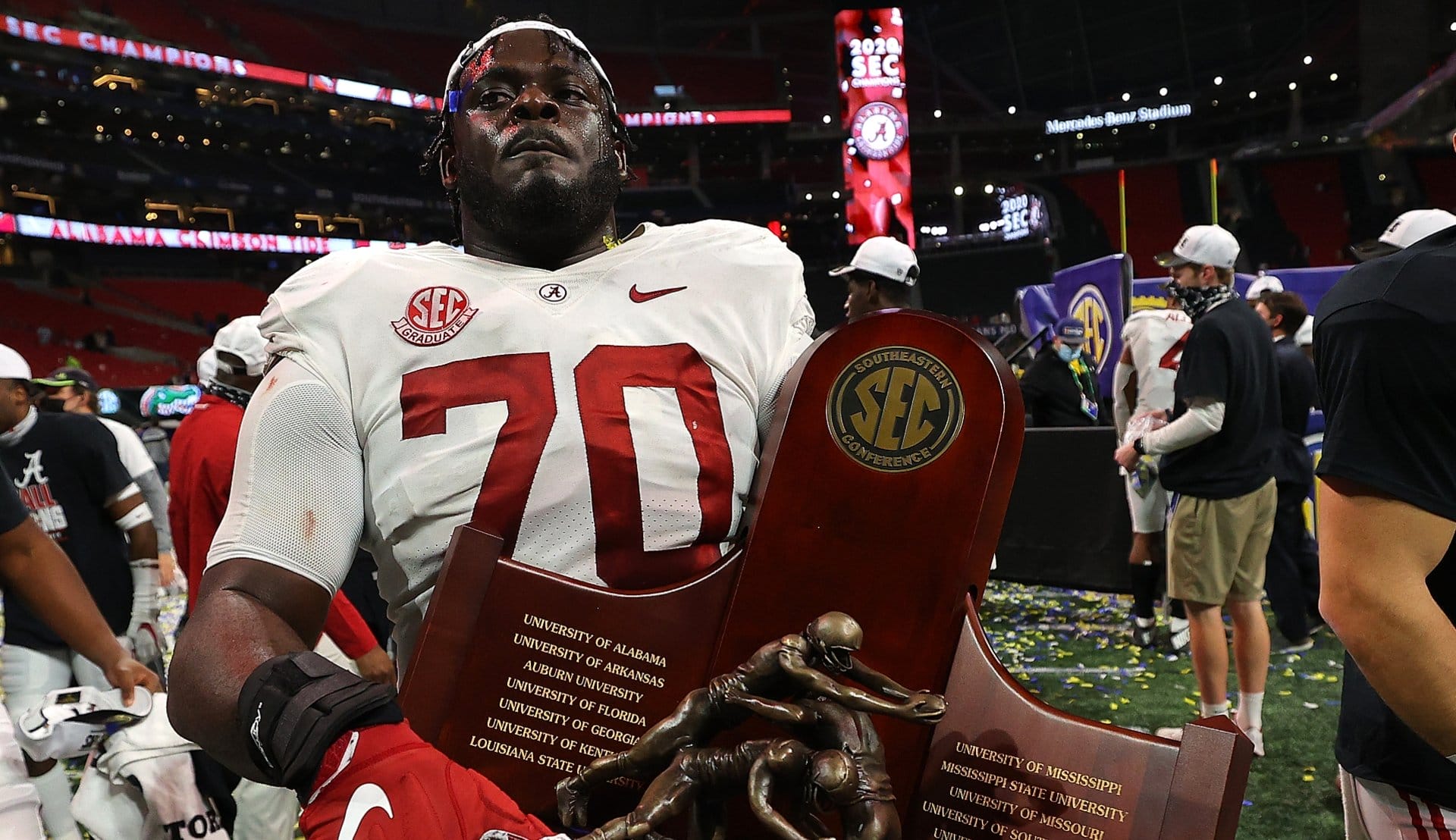 Alex Leatherwood #70 of the Alabama Crimson Tide carries the trophy after their 52-46 win over the Florida Gators in the SEC Championship at Mercedes-Benz Stadium on December 19, 2020 in Atlanta, Georgia. (Photo by Kevin C. Cox/Getty Images)
