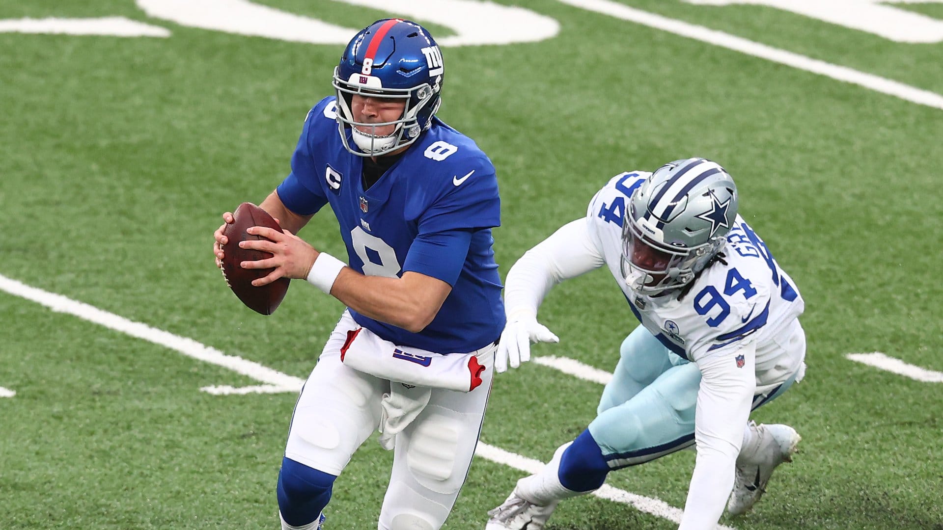 EAST RUTHERFORD, NEW JERSEY - JANUARY 03: Daniel Jones #8 of the New York Giants is pursued by Randy Gregory #94 of the Dallas Cowboys during the first quarter at MetLife Stadium on January 03, 2021 in East Rutherford, New Jersey. (Photo by Mike Stobe/Getty Images)