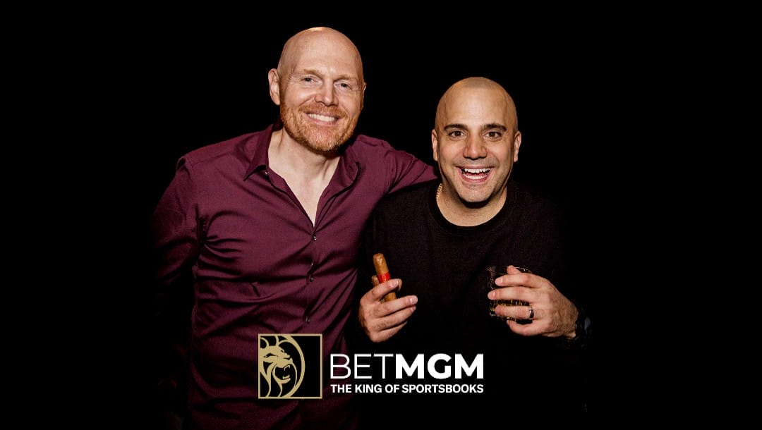 Bill Burr and Paul Virzi posing together over a black background with the BetMGM logo overimposed on the picture.