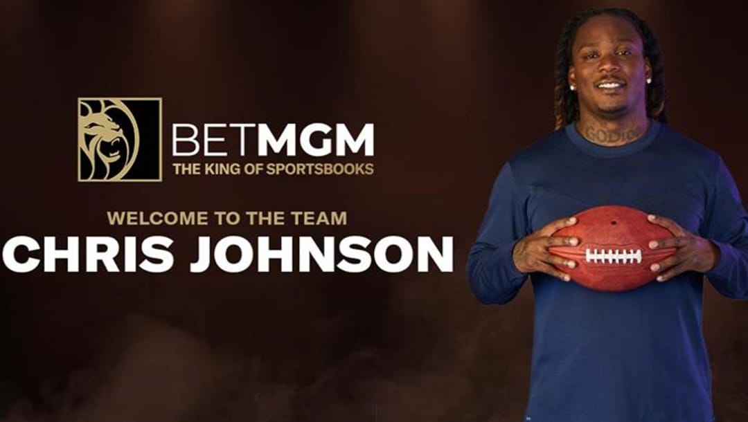Former NFL player Chris Johnson holding a football on a dark background