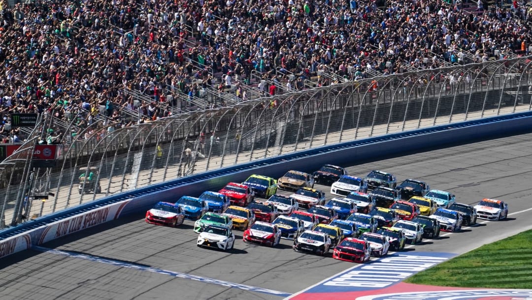 NASCAR Cup Series cars line up five wide in a salute to fans during pace laps for the NASCAR Cup Series auto race at Auto Club Speedway, in Fontana, Calif., Sunday, March 17, 2019. (AP Photo/Rachel Luna)