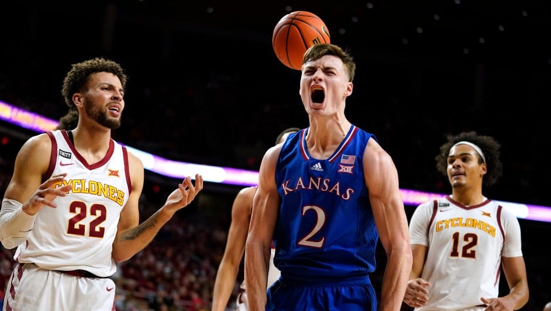 Kansas guard Christian Braun (2) celebrates ahead of Iowa State guard Gabe Kalscheur (22) and forward Robert Jones (12) after making a basket during the second half of an NCAA college basketball game, Tuesday, Feb. 1, 2022, in Ames, Iowa. (AP Photo/Charlie Neibergall)