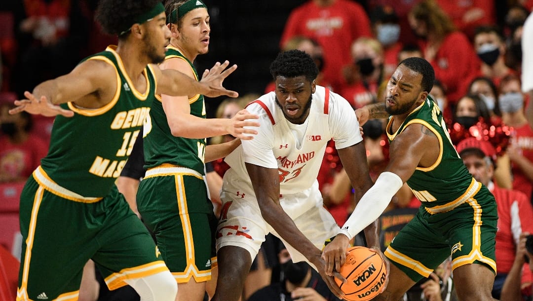 Maryland forward Qudus Wahab (33) is pressured by George Mason guard DeVon Cooper, right, forward Josh Oduro, second from the left, and guard D'Shawn Schwartz, left, during the first half of an NCAA college basketball game Wednesday, Nov. 17, 2021, in College Park, Md. (AP Photo/Nick Wass)