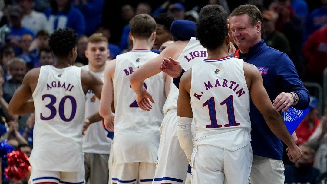 Kansas head coach Bill Self congratulates his starters during the second half of a college basketball game in the Elite 8 round of the NCAA tournament Sunday, March 27, 2022, in Chicago.