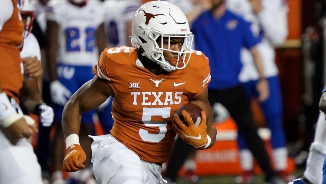 Texas running back Bijan Robinson (5) runs against Kansas during the first half of an NCAA college football game in Austin, Texas, Saturday, Nov. 13, 2021.