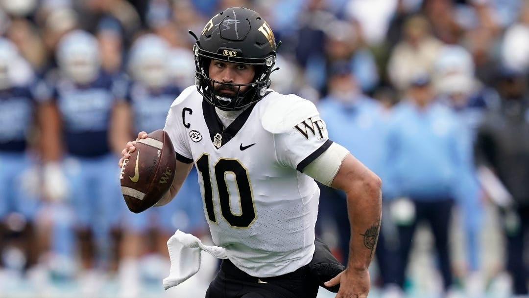 Wake Forest quarterback Sam Hartman (10) scrambles against North Carolina during the first half of an NCAA college football game in Chapel Hill, N.C., Saturday, Nov. 6, 2021. (AP Photo/Gerry Broome)