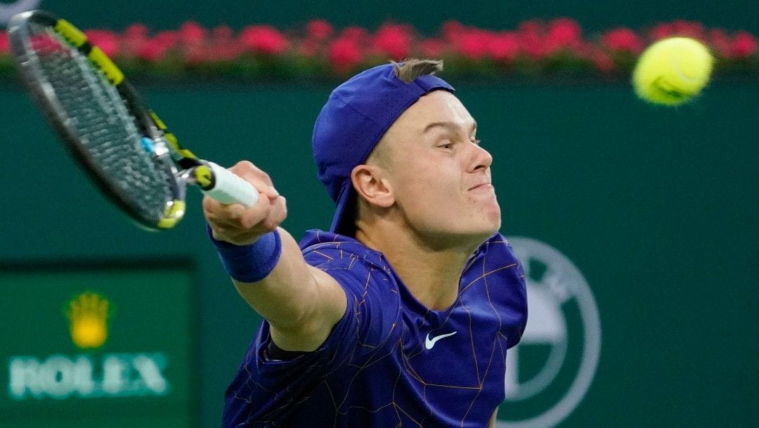 Holger Rune, of Denmark, returns a shot to Matteo Berrettini, of Italy, at the BNP Paribas Open tennis tournament Sunday, March 13, 2022, in Indian Wells, Calif.