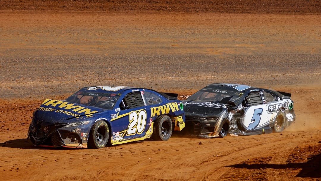 Driver Kyle Larson (5) pushes Christopher Bell (20) after a wreck during a NASCAR Cup Series auto race, Monday, March 29, 2021, in Bristol, Tenn. (AP Photo/Wade Payne)