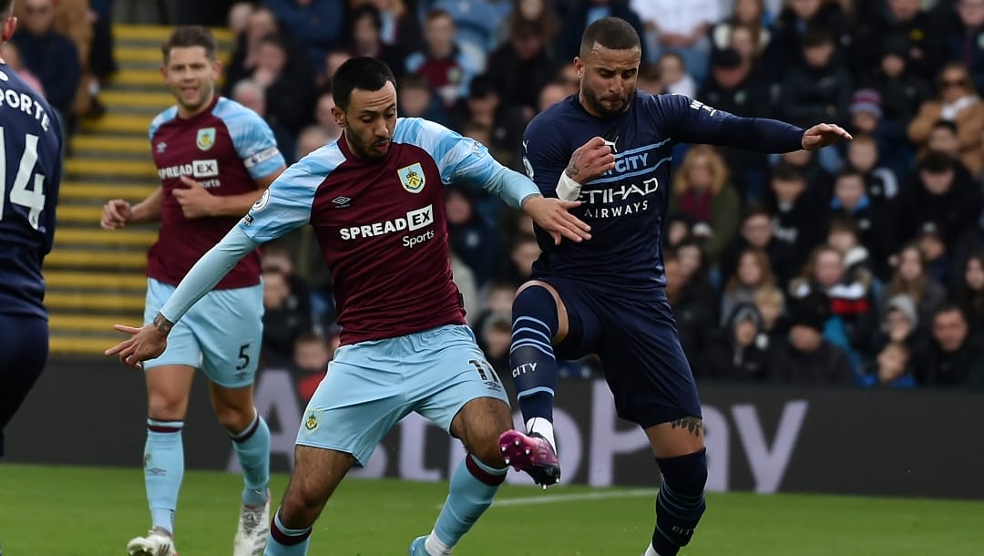 Manchester City's Kyle Walker, right, fights for the ball with Burnley's Dwight McNeil during the Premier League soccer match between Burnley and Manchester City at Turf Moor, in Burnley, England, Saturday, April 2, 2022. (AP Photo/Rui Vieira)