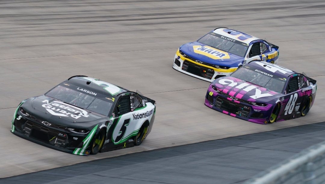Kyle Larson, left, in action against Alex Bowman, center, and Chase Elliott, right, during a NASCAR Cup Series auto race at Dover International Speedway, Sunday, May 16, 2021, in Dover, Del. (AP Photo/Chris Szagola)