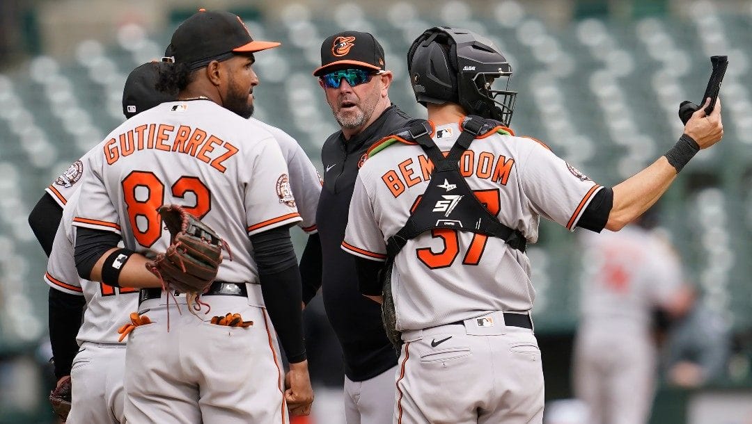 Baltimore Orioles manager Brandon Hyde, middle, stands on the mound while making a pitching change during the eighth inning of his team's baseball game against the Oakland Athletics in Oakland, Calif., Wednesday, April 20, 2022.