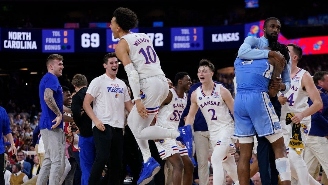 North Carolina guard Caleb Love, right, reacts to a loss as Kansas' Jalen Wilson (10) celebrates after a college basketball game in the finals of the Men's Final Four NCAA tournament, Monday, April 4, 2022, in New Orleans. Kansas won 72-69.