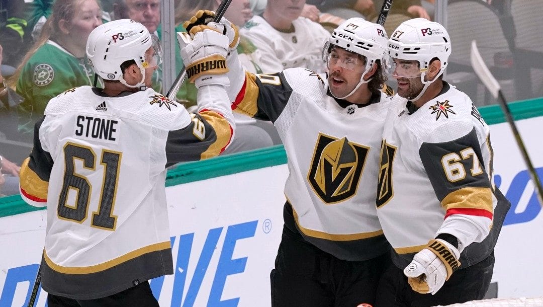 Vegas Golden Knights center Chandler Stephenson (20) celebrates his goal with Mark Stone (61) and Max Pacioretty (67) during the second period of an NHL hockey game against the Dallas Stars in Dallas, Tuesday, April 26, 2022.
