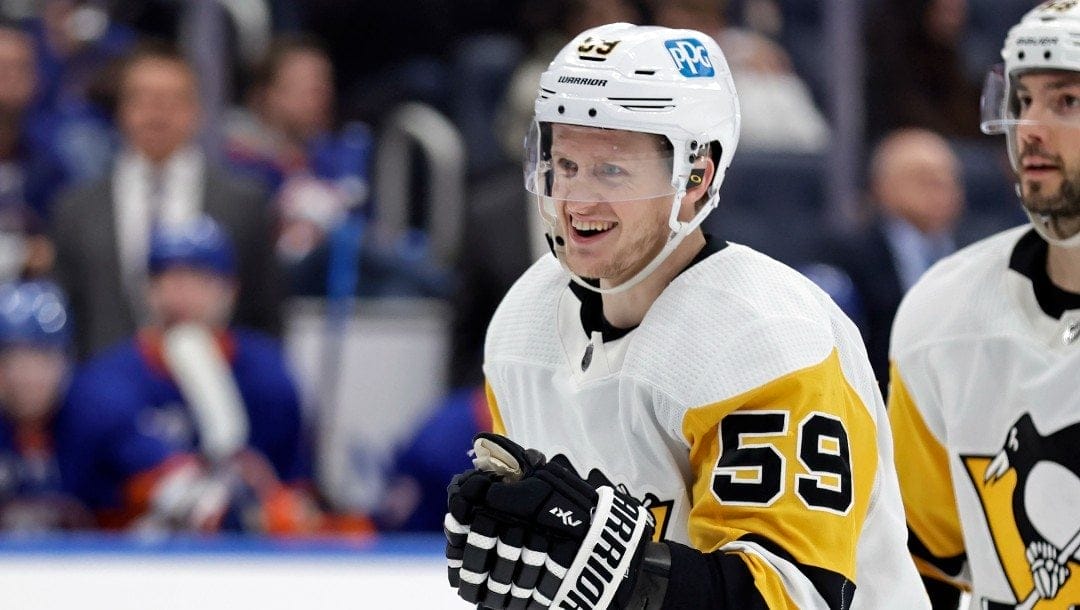 Pittsburgh Penguins left wing Jake Guentzel (59) reacts after scoring a goal against the New York Islanders in the third period of an NHL hockey game Tuesday, April 12, 2022, in Elmont, N.Y.