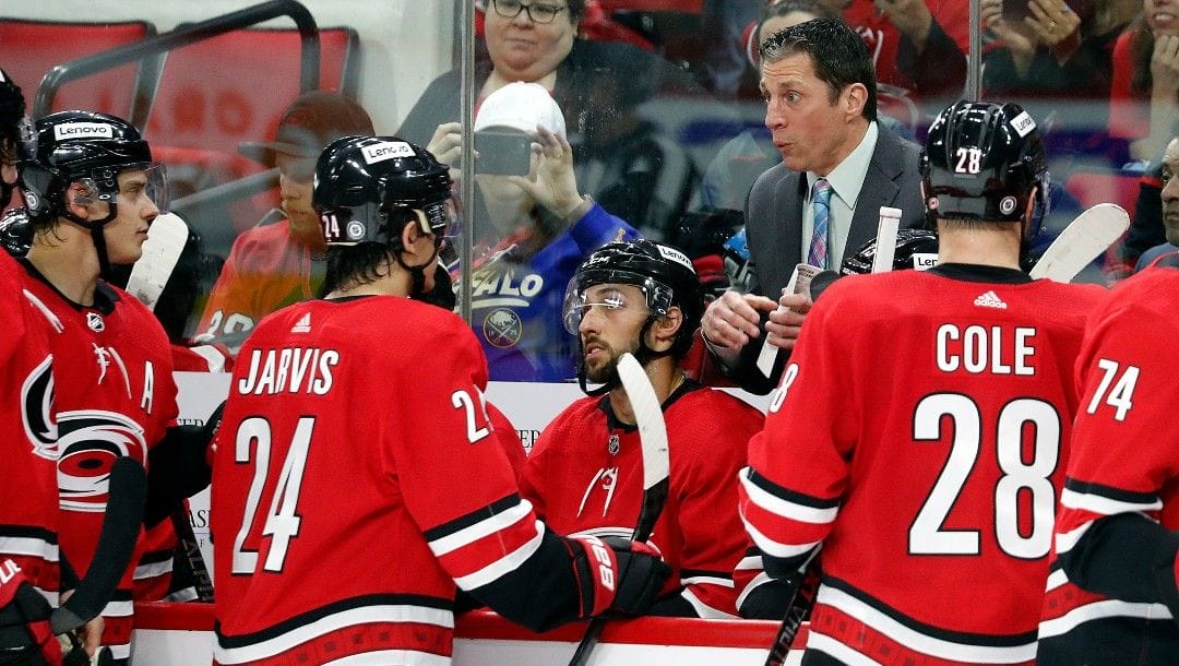 Carolina Hurricanes coach Rod Brind'Amour talks with the team during a timeout in the third period of the team's NHL hockey game against the Buffalo Sabres in Raleigh, N.C., Thursday, April 7, 2022.