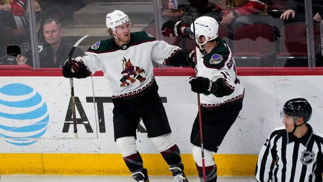 Arizona Coyotes center Travis Boyd, left, celebrates with defenseman Shayne Gostisbehere after scoring a goal during the second period of the team's NHL hockey game against the Chicago Blackhawks in Chicago, Sunday, April 3, 2022.