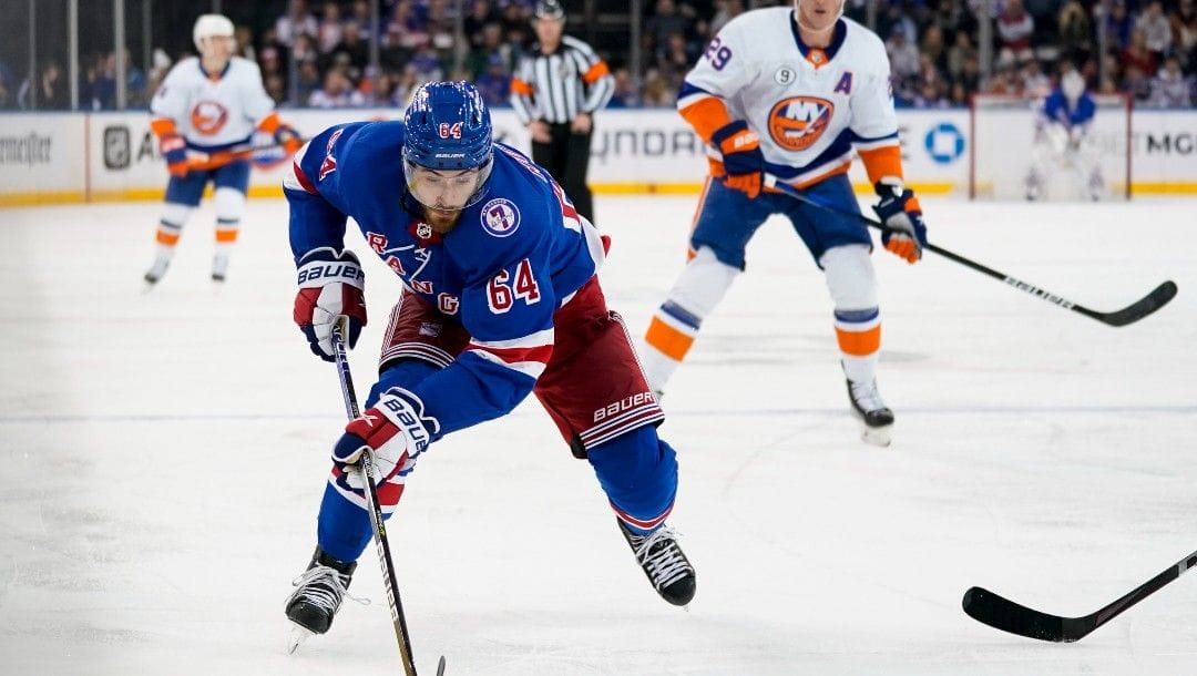 New York Rangers center Tyler Motte (64) skates the puck up the ice during the second period of an NHL hockey game against the New York Islanders, Friday, April 1, 2022, in New York.