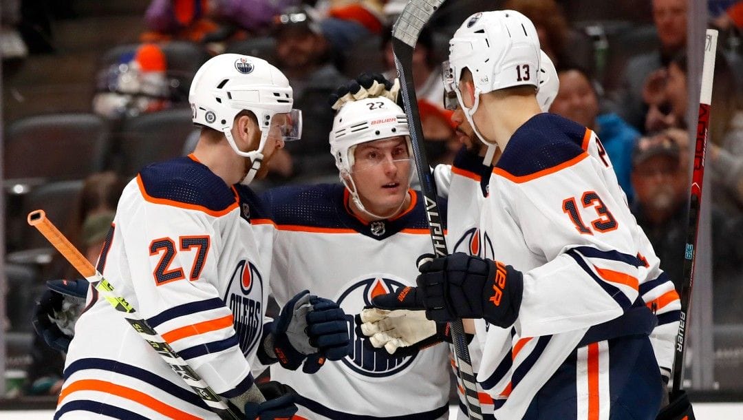 Edmonton Oilers defenseman Tyson Barrie (22) celebrates scoring against the Anaheim Ducks with defenseman Brett Kulak (27), left wing Evander Kane, second from right, and right wing Jesse Puljujarvi (13) during the first period of an NHL hockey game in Anaheim, Calif., Sunday, April 3, 2022.