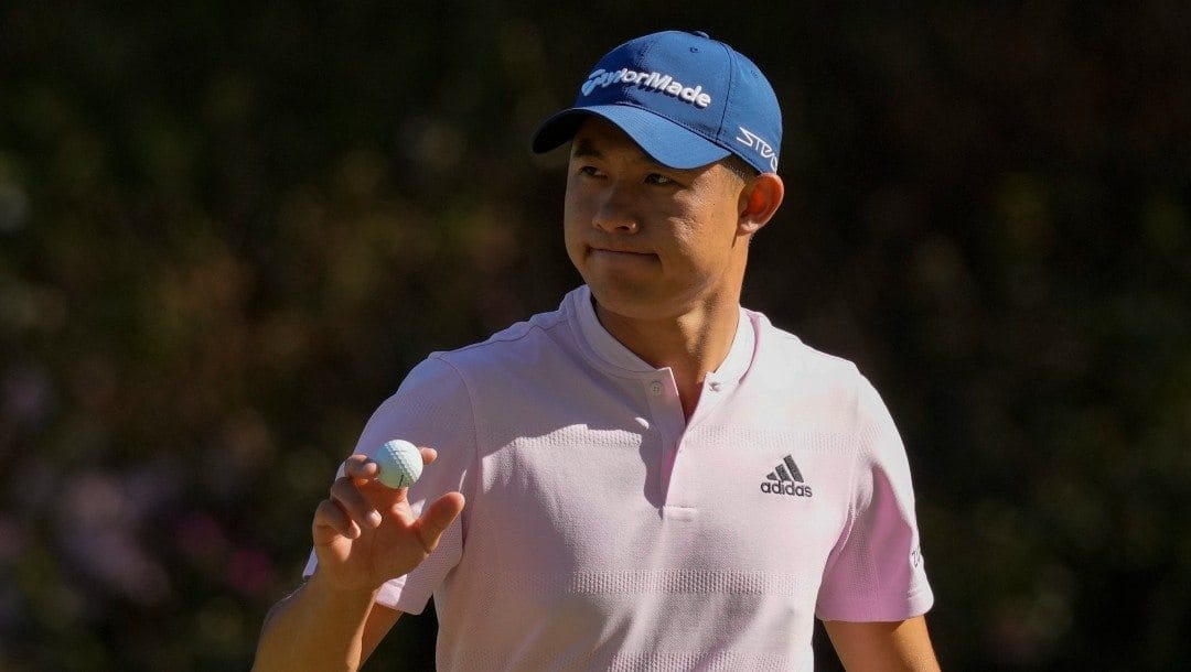 Collin Morikawa holds up his ball after an eagle putt on the 13th hole during the final round at the Masters golf tournament on Sunday, April 10, 2022, in Augusta, Ga.