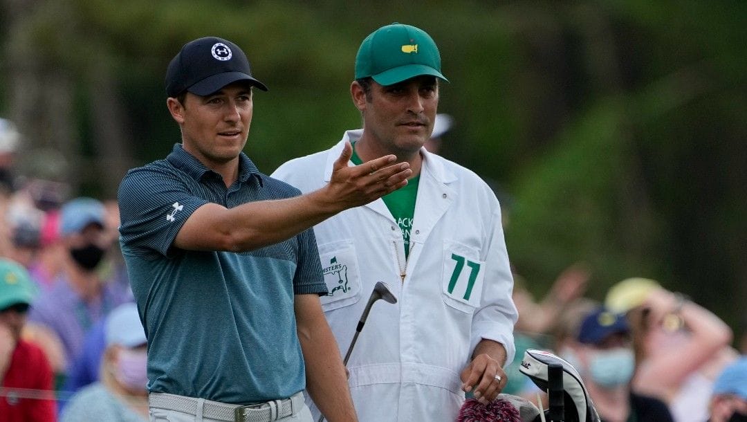 In this Sunday, April 11, 2021 file photo, Jordan Spieth discusses his tee shot with his caddie Michael Greller on the 12th hole during the final round of the Masters golf tournament, in Augusta, Ga.