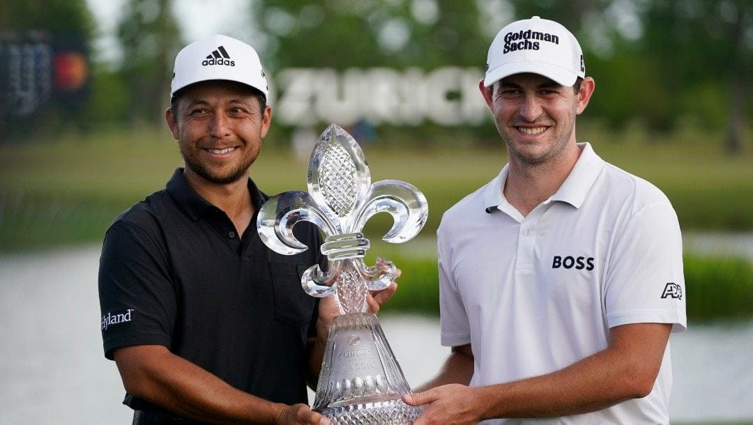 Xander Schauffele, left, and teammate Patrick Cantlay, right, hold up the trophy after winning the PGA Zurich Classic golf tournament at TPC Louisiana in Avondale, La., Sunday, April 24, 2022.