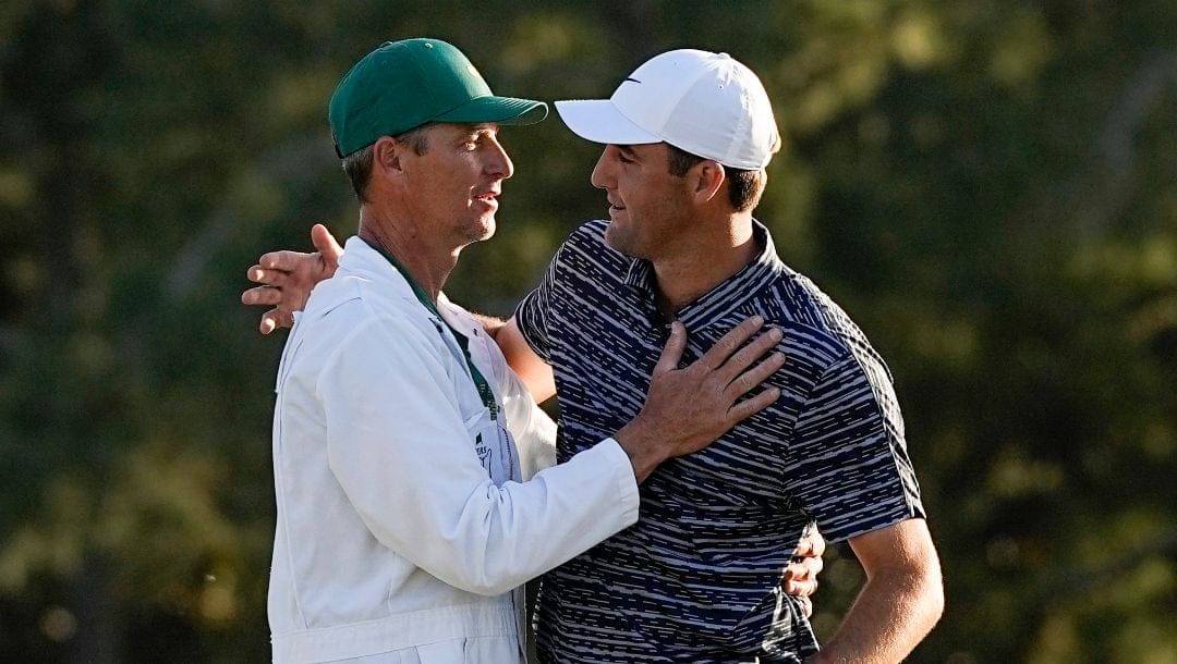 Scottie Scheffler celebrates with his caddie Ted Scott after winning the 86th Masters golf tournament on Sunday, April 10, 2022, in Augusta, Ga.