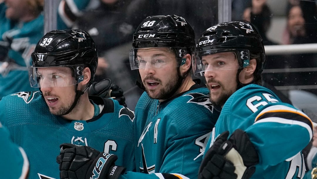 San Jose Sharks center Tomas Hertl, center, is congratulated by Logan Couture, left, and Erik Karlsson, right, after scoring a goal against the Edmonton Oilers during the first period of an NHL hockey game Tuesday, April 5, 2022, in San Jose, Calif. (AP Photo/Tony Avelar)
