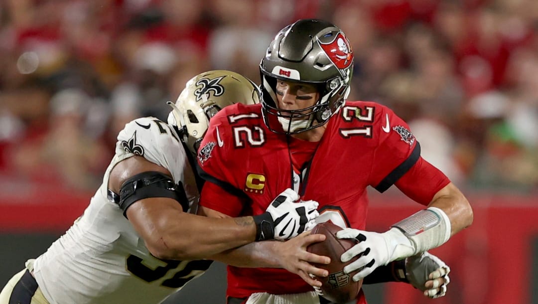 Tampa Bay Buccaneers quarterback Tom Brady (12) is sacked by New Orleans Saints defensive end Marcus Davenport (92) during an NFL football game against the New Orleans Saints, Sunday Dec. 19th, 2021 in Tampa, Fla. (AP Photo/Don Montague)