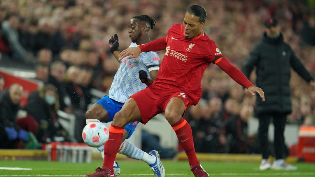 Liverpool's Virgil van Dijk, right, fights for the ball with Manchester United's Aaron Wan-Bissaka during the English Premier League soccer match between Liverpool and Manchester United at Anfield stadium in Liverpool, England, Tuesday, April 19, 2022.