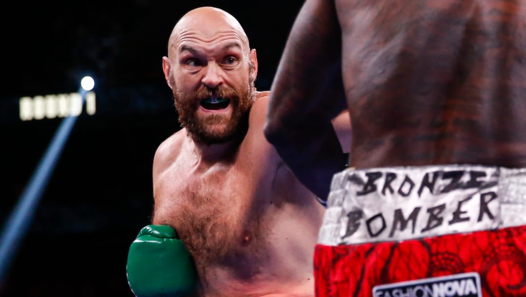 Tyson Fury, of England, hits Deontay Wilder in a heavyweight championship boxing match Saturday, Oct. 9, 2021, in Las Vegas.