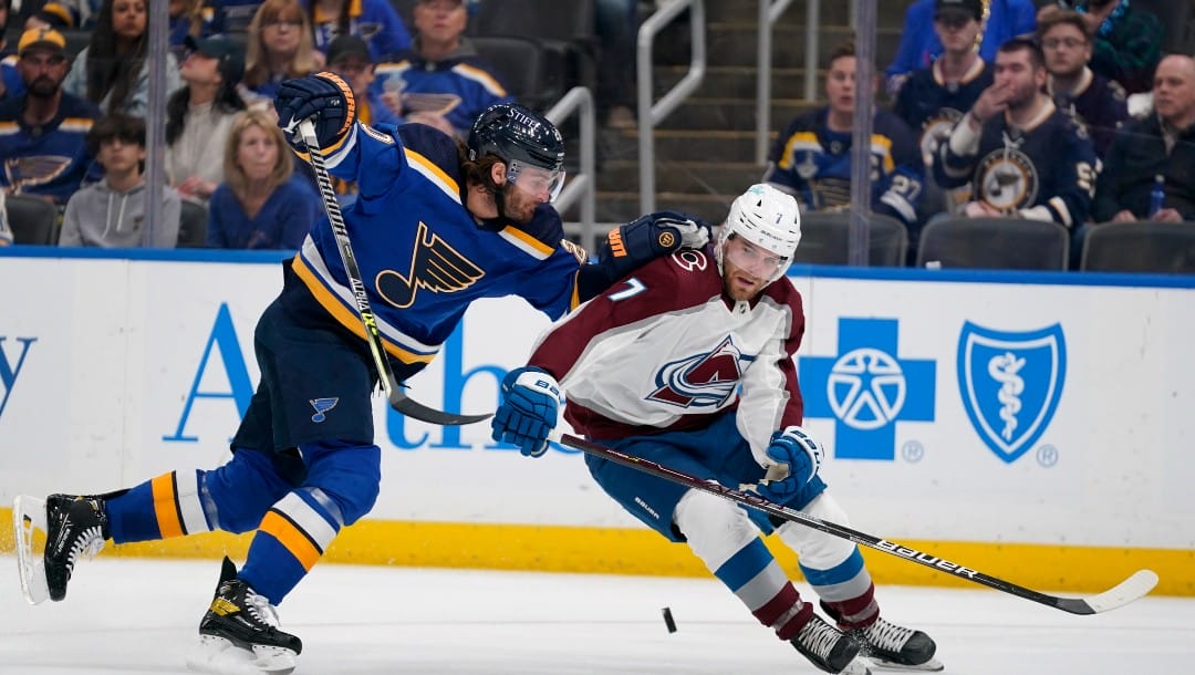 St. Louis Blues' Brandon Saad and Colorado Avalanche's Devon Toews (7) battle for a loose puck during the second period in Game 4 of an NHL hockey Stanley Cup second-round playoff series Monday, May 23, 2022, in St. Louis.