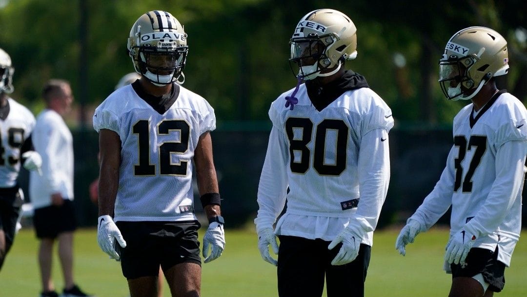 New Orleans Saints wide receivers Chris Olave (12), Kawaan Baker (80) and Jalen McCleskey (87) pause between drills during the NFL football team's rookie minicamp in Metairie, La., Saturday, May 14, 2022.