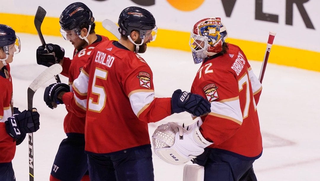 Florida Panthers defenseman Aaron Ekblad (5) and goaltender Sergei Bobrovsky (72) celebrate their 5-1 victory at the end of Game 2 of an NHL hockey first-round playoff series against the Washington Capitals, Thursday, May 5, 2022, in Sunrise, Fla.