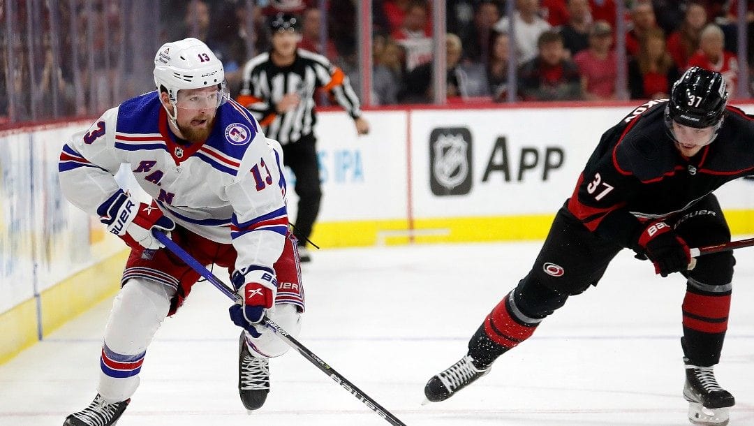 New York Rangers' Alexis Lafrenière (13) skates with the puck in front of Carolina Hurricanes' Andrei Svechnikov (37) during the third period of Game 1 of an NHL hockey Stanley Cup second-round playoff series in Raleigh, N.C., Wednesday, May 18, 2022.