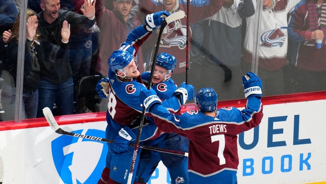 Colorado Avalanche defenseman Cale Makar (8) is congratulated by center Nico Sturm (78) and defenseman Devon Toews (7) after scoring the against the Nashville Predators during overtime in Game 2 of an NHL hockey Stanley Cup first-round playoff series Thursday, May 5, 2022, in Denver. The Avalanche won 2-1.