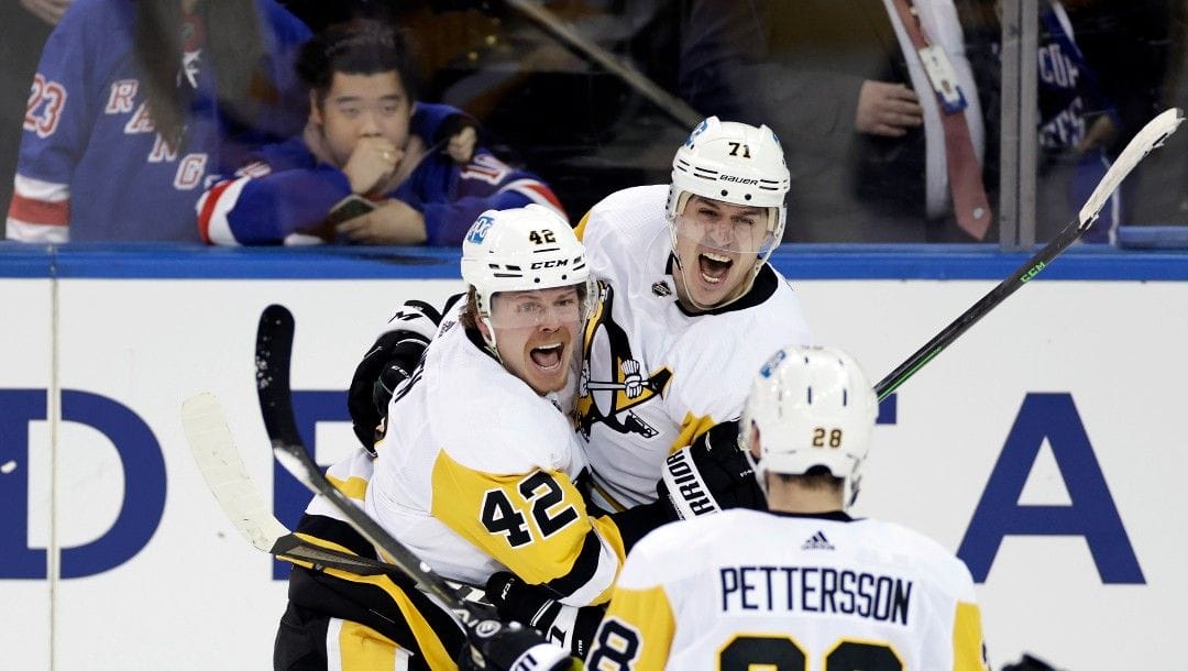Pittsburgh Penguins center Evgeni Malkin (71) celebrates with teammates after scoring against the New York Rangers during the third overtime in Game 1 of an NHL hockey Stanley Cup first-round playoff series, Tuesday, May 3, 2022, in New York. The Penguins won 4-3.