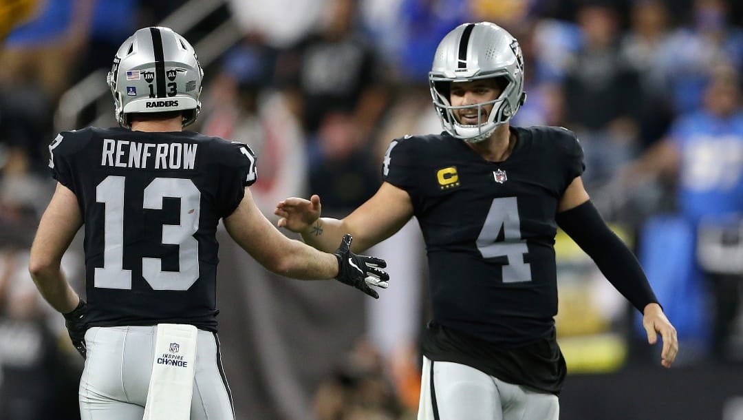 Las Vegas Raiders wide receiver Hunter Renfrow (13) and Las Vegas Raiders quarterback Derek Carr (4) celebrate after a play against the Los Angeles Chargers during the first half of an NFL football game, Sunday, Jan. 9, 2022, in Las Vegas. (AP Photo/Ellen Schmidt)