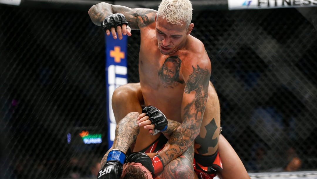 Charles Oliveira, top, fights Dustin Poirier during a lightweight mixed martial arts title bout at UFC 269, Saturday, Dec. 11, 2021, in Las Vegas.