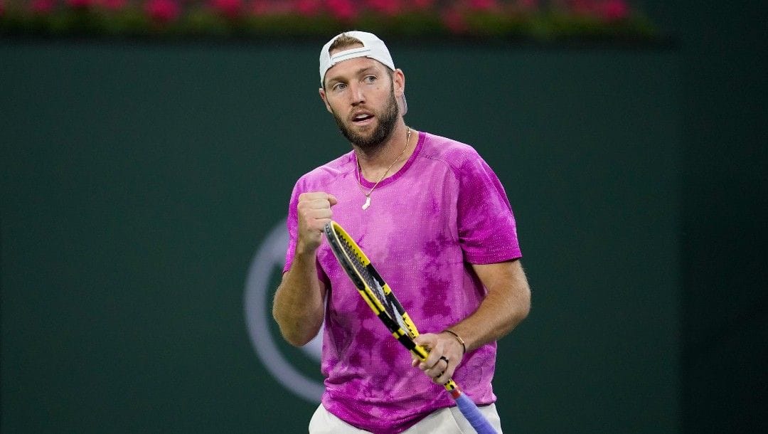 Jack Sock reacts after a shot to Stefanos Tsitsipas, of Greece, at the BNP Paribas Open tennis tournament Saturday, March 12, 2022, in Indian Wells, Calif.