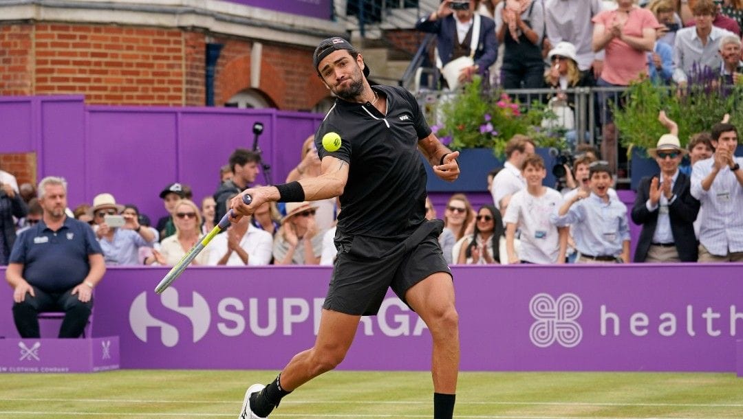 Italy's Matteo Berrettini hits the ball into the crowd as he celebrates after beating Serbia's Filip Krajinovic to win the final tennis match at the Queen's Club Championships in London, Sunday, June 19, 2022.