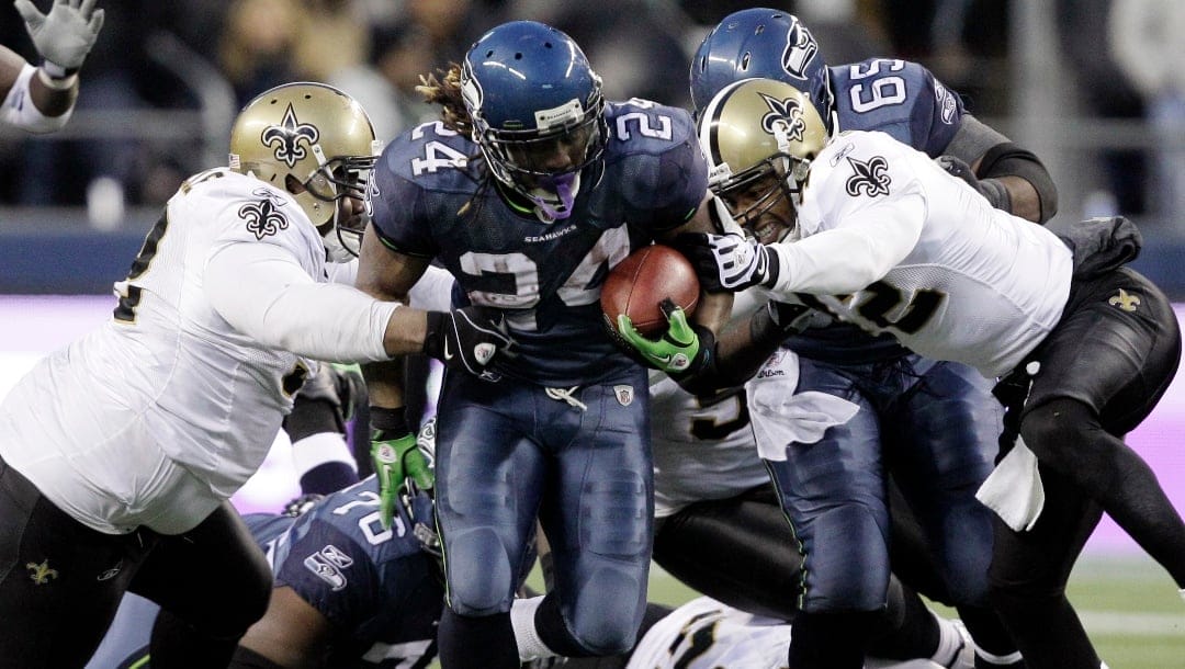 Seattle Seahawks' Marshawn Lynch (24) breaks away from a tackle by the New Orleans Saints defenders to score a touchdown in the second half of an NFL NFC wild card playoff football game, Saturday, Jan. 8, 2011, in Seattle. (AP Photo/Elaine Thompson)