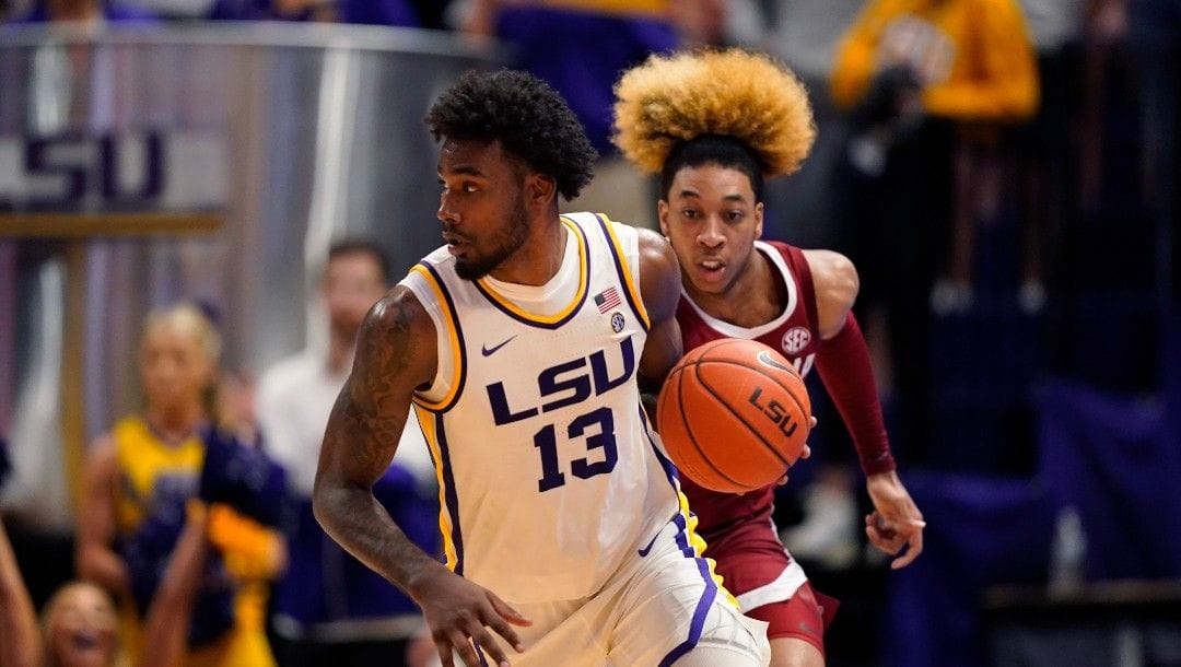 LSU forward Tari Eason (13) moves the ball past Alabama guard JD Davison in the second half an NCAA college basketball game in Baton Rouge, La., Saturday, March 5, 2022. LSU won in overtime 80-77.